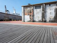 an old factory building is set next to the empty street with its side walk boards