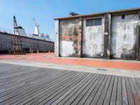 an old factory building is set next to the empty street with its side walk boards