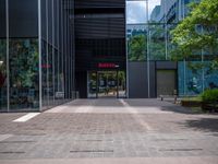 a picture of the entrance of a building with glass and metal doors and windows on the side