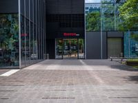 a picture of the entrance of a building with glass and metal doors and windows on the side