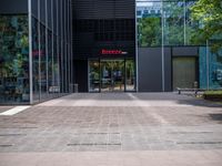 a picture of the entrance of a building with glass and metal doors and windows on the side