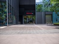 a picture of the entrance of a building with glass and metal doors and windows on the side