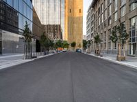 a street is pictured in the photo with tall buildings on either side and no one standing or walking across it