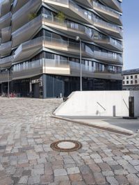 the building is very tall and elegant in this picture of the street and walkway in front of it