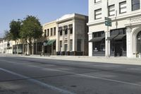 a very tall, white building on the corner of a city street with windows and doors
