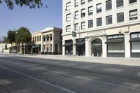 a very tall, white building on the corner of a city street with windows and doors
