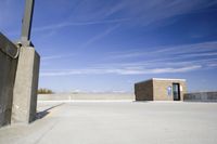 a fire hydrant sits in front of a tan building with no windows on the cement