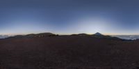 a very wide camera view of the mountains around crater teide with two people and a bike