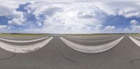 an airplane flying over a tarmac at an airport with a cloudy sky in the background