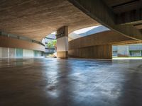 the empty entrance to a building with many floors and benches sitting on the ground with one light shining