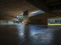 the empty entrance to a building with many floors and benches sitting on the ground with one light shining