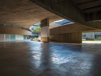 the empty entrance to a building with many floors and benches sitting on the ground with one light shining