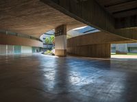 the empty entrance to a building with many floors and benches sitting on the ground with one light shining