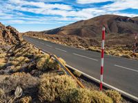 an open road in the desert with two red and white stripes running along it,