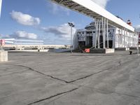 an empty parking lot with a cargo ship in the background and a traffic light at the corner