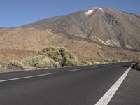 a road that goes to the top of a mountain with a large black sign on it