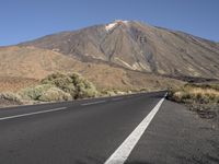 a road that goes to the top of a mountain with a large black sign on it