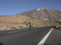 a road that goes to the top of a mountain with a large black sign on it