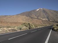 a road that goes to the top of a mountain with a large black sign on it