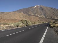 a road that goes to the top of a mountain with a large black sign on it