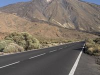 a road that goes to the top of a mountain with a large black sign on it