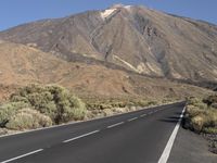 a road that goes to the top of a mountain with a large black sign on it