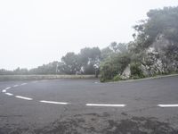 a person riding on the back of a motorcycle down a hill in an empty parking lot