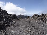 a view of the lava with clouds and trees behind it, in a mountainous area