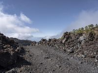 a view of the lava with clouds and trees behind it, in a mountainous area