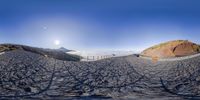 a 360 - angle view of a mountainous landscape in a fisheye lens mirror,