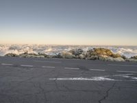 the view over the clouds from the top of the mountains on a clear day by the street