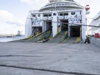 a large ship sitting next to the water with stairs leading down to it's doors