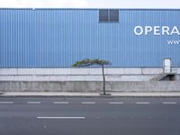 a building on a corner with an entrance leading into it and a sign reading opera music