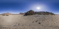 the sun is shining over the desert like mountain range seen from below a fish - eye lens