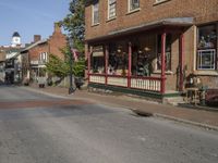 the old fashioned store is next to a street corner with antique items on display in front