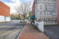 an empty parking lot next to a brick building with sign on it saying, no drive away burger bar