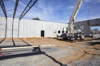 a construction crane lifts material out of the hole into the ground area for a concrete structure