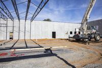 a construction crane lifts material out of the hole into the ground area for a concrete structure