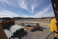 bulldozer and truck and building materials in foreground on construction site with blue sky