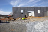 a concrete building being constructed, including a hard hat on the ground, in the process of being completed