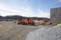 a couple of red ski lifts near a construction site, under construction and on a sunny day