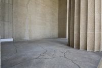 a large concrete building with columns and an arch in the center of it that appears to be used as a room for a cell phone