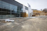 a large building that has a glass wall in front of it and bags sitting on the ground