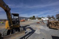 there is a backhoe for the tractor in the parking lot near the building site