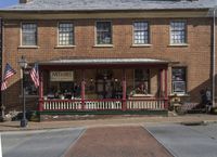 an old red brick house with flags and flags hanging from the porches and front of it