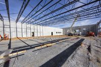 large, open and empty industrial warehouse in progress for construction works on the ground and inside