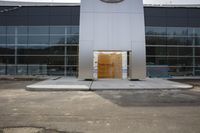 an outdoor photo of a commercial building with a wooden entrance door in front of it