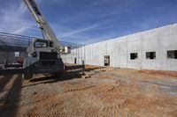 a large crane that is next to a building being built to work on a project