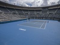 two tennis players are playing on the court at a tennis stadium that has blue and white colors