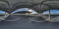 a fish eye view of the parking lot outside a tennis stadium covered by solar panels